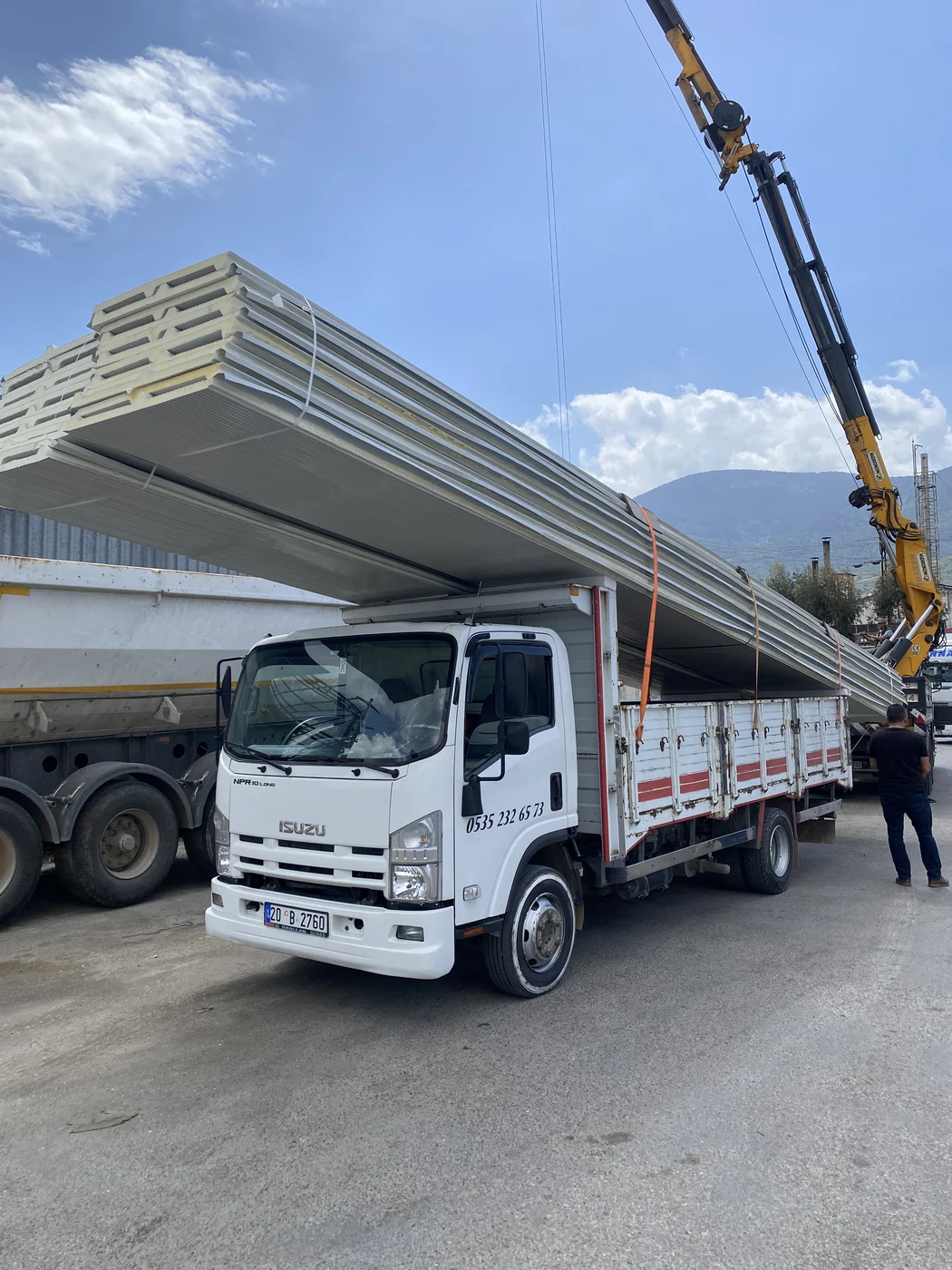 Isuzu kamyonet ve vinç ile uzun çatı ve cephe sandviç panel yüklemesi